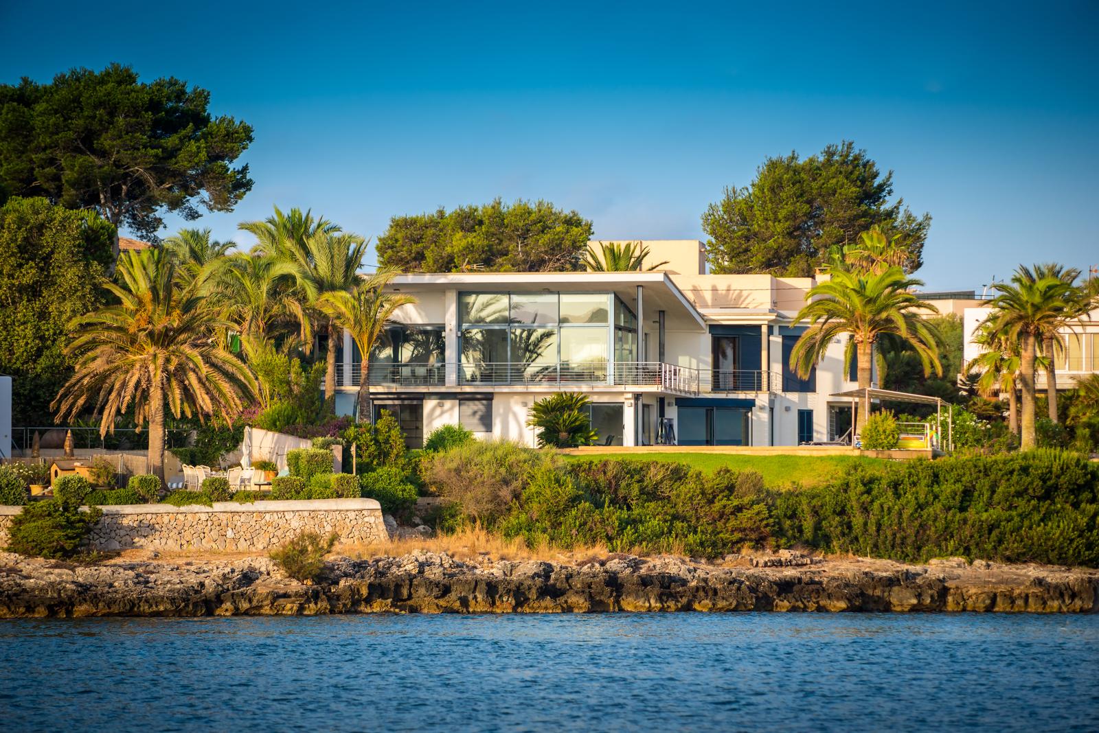 Contemporary waterfront villa among palm trees